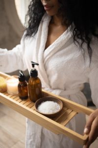 crop black woman with skincare products